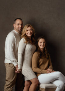 family of three in a family photo on brown